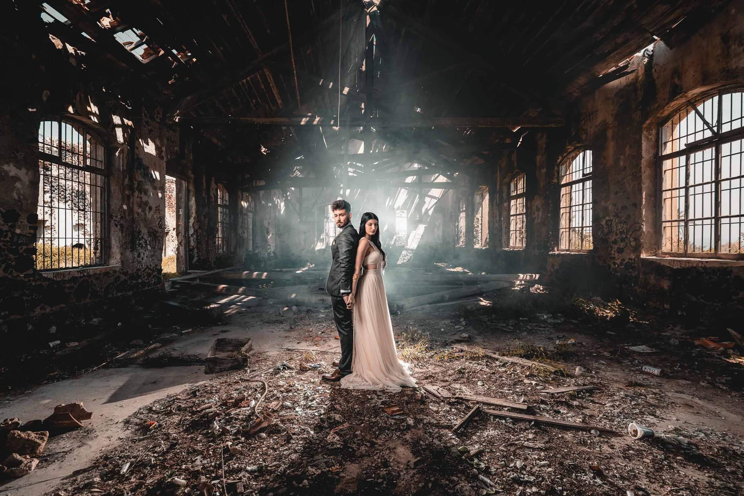 Wedding couple posing at the ruins of an abandoned factory in Santorini.