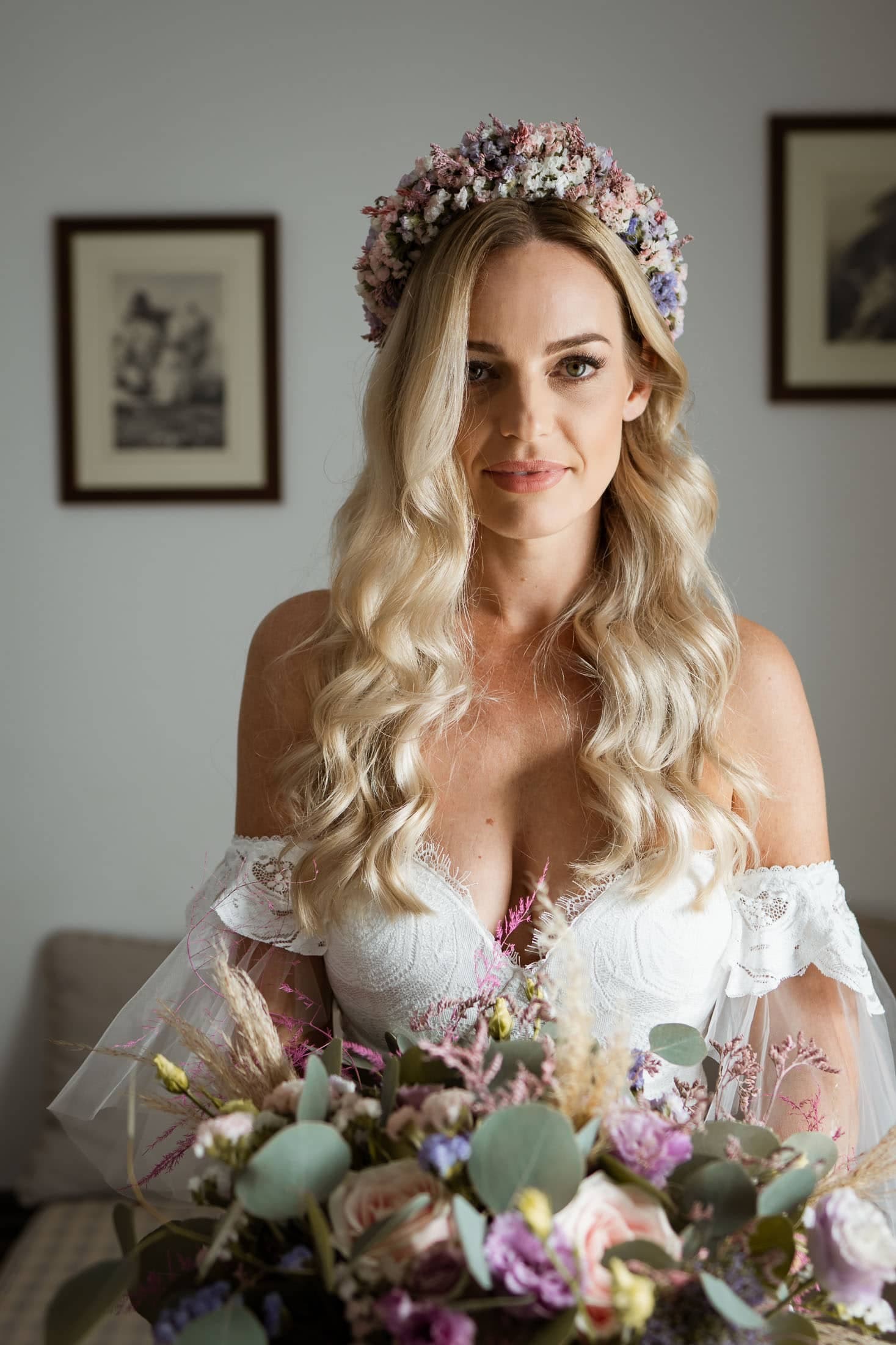 Bride getting ready in a private villa in Santorini Greece. She's holding her bridal bouquet in her hands.