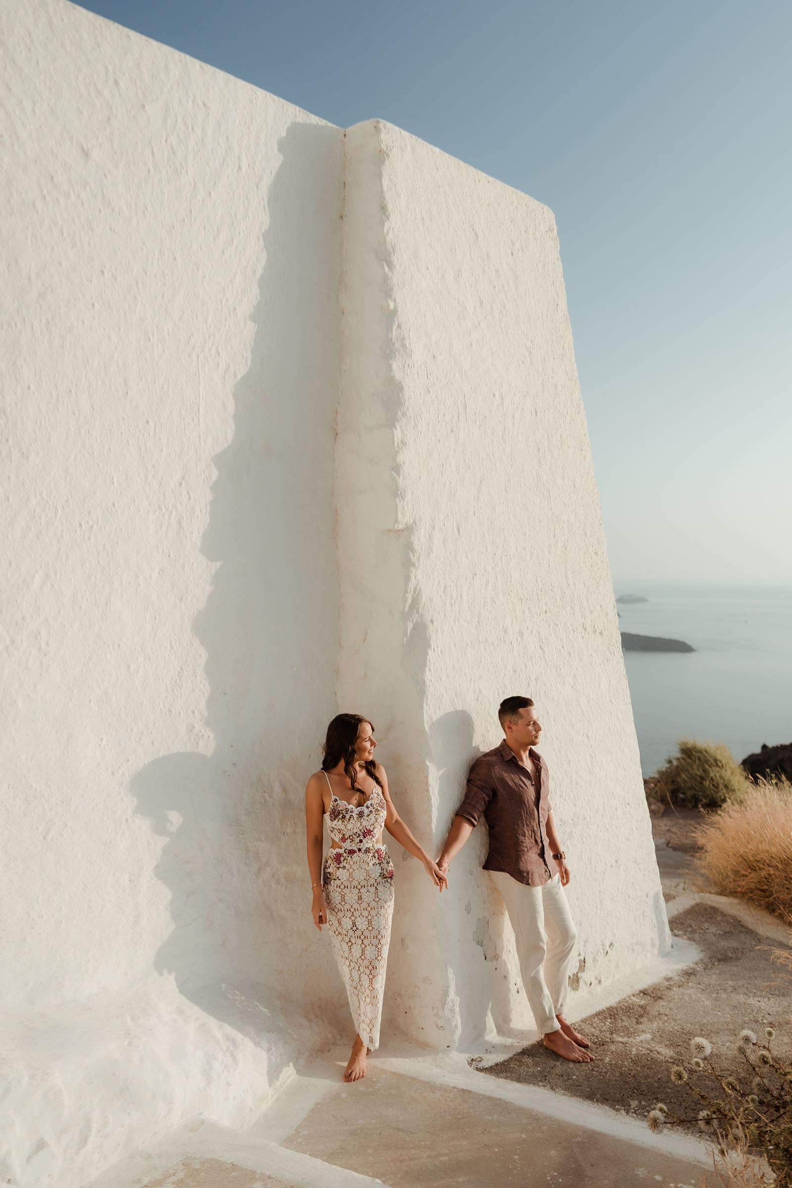 Couple holding hands, enjoying their couple photoshoot in Santorini Greece.