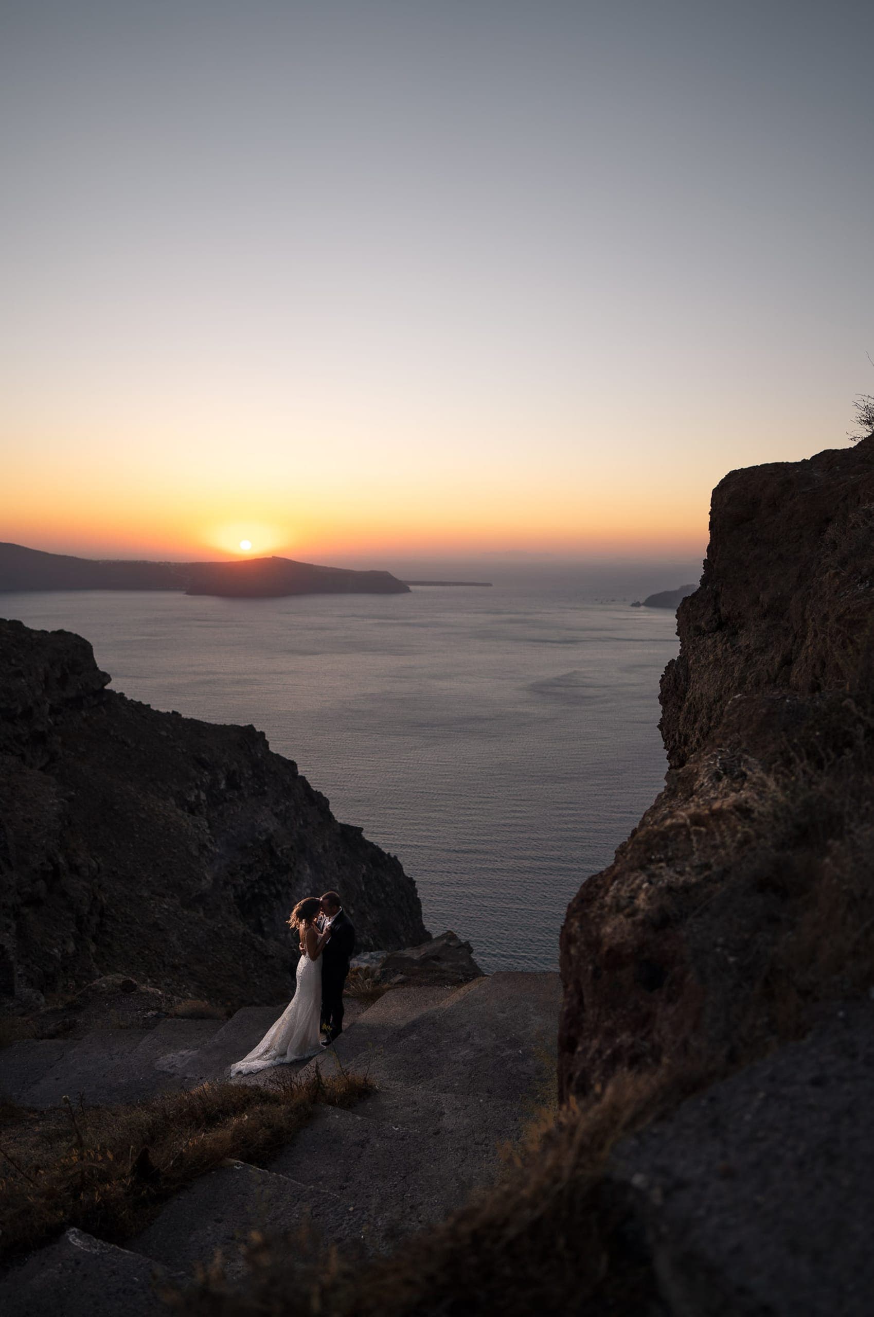 Wedding couple posing at Skaros rock at sunset time.