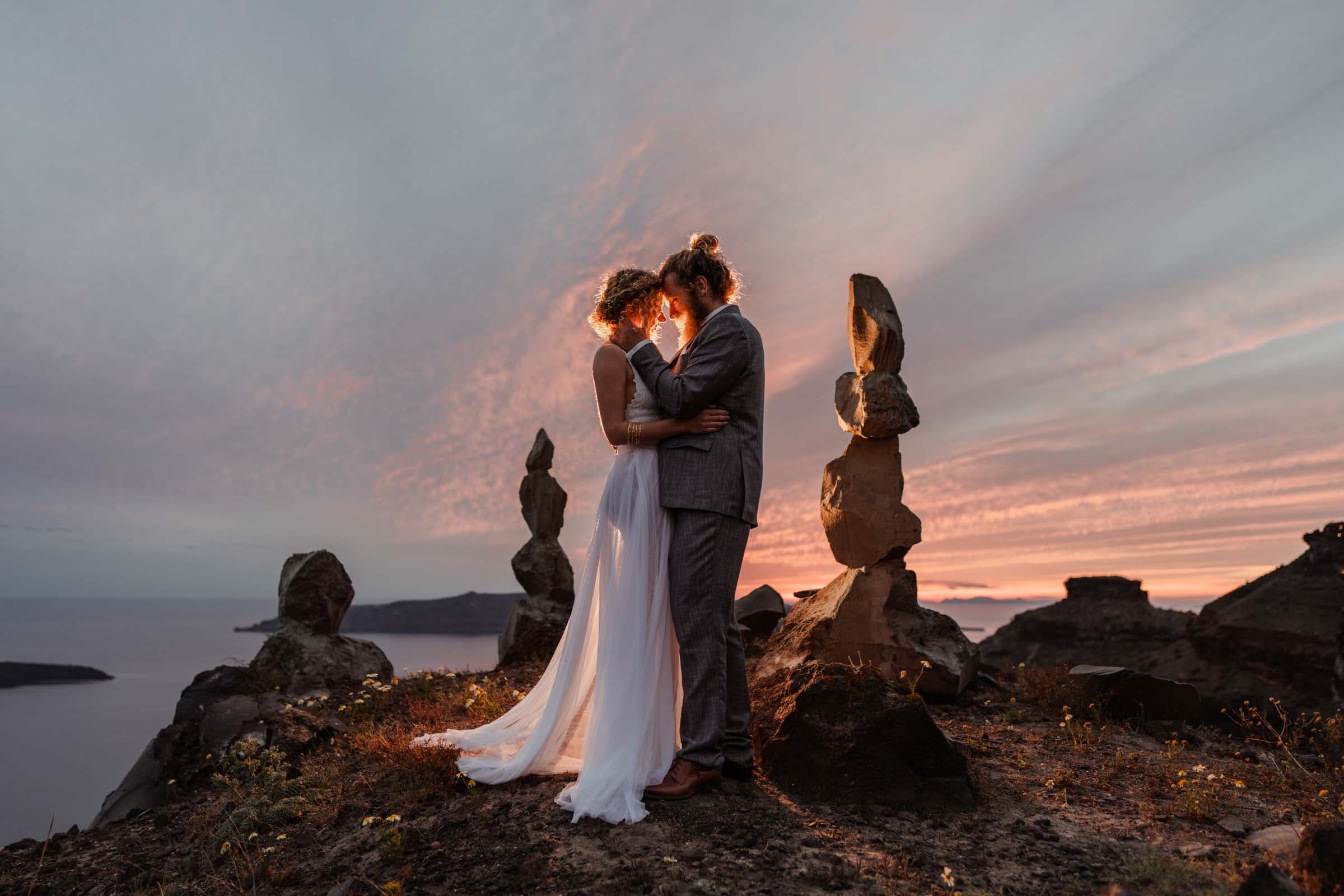Wedding couple possing during their wedding photoshoot in Skaros rock, Santorini.